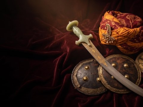 A Mughal-era talwar with a jade hilt, a Rajput pagri and a dhal shield on maroon velvet